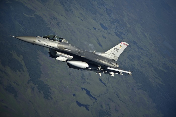 F-16 Fighting Falcon in flight over terrain