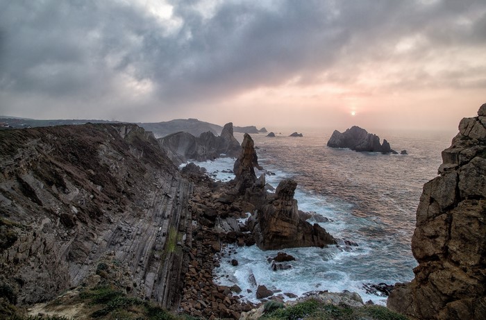 Rocky coastline with waves at sunset