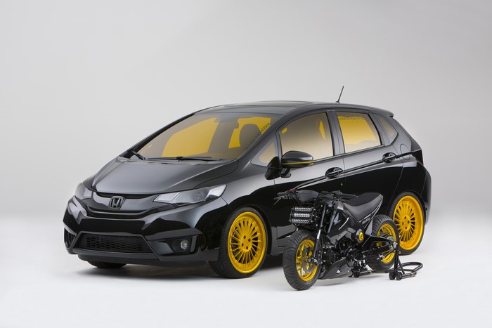 Black Honda Fit with Yellow Accents and Motorcycle