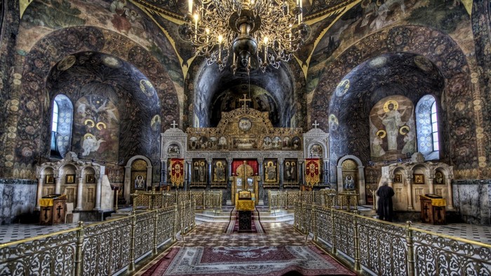 Interior of a richly decorated Orthodox church with icons and frescoes