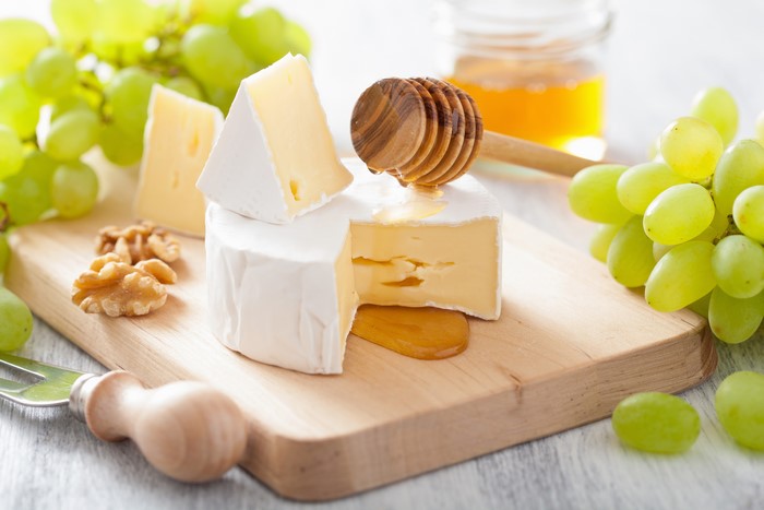 Cheese, Grapes, and Honey on a Wooden Board