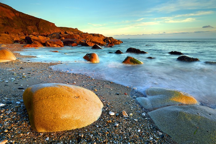Rocky beach with waves at sunset