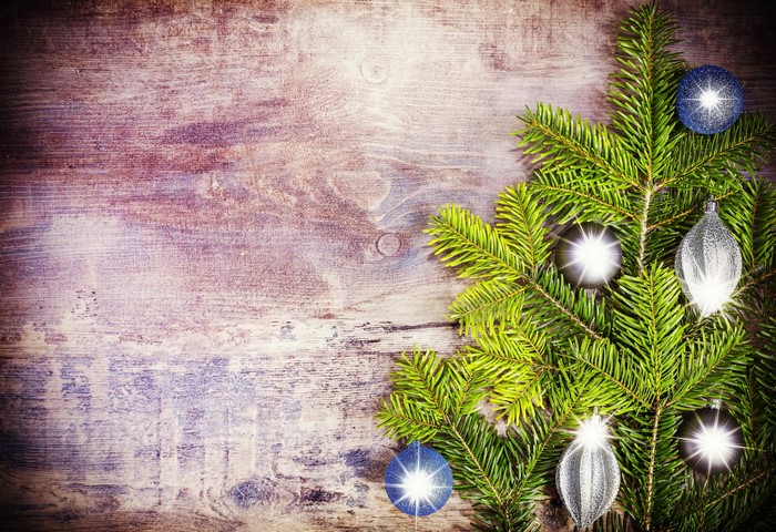 Christmas tree branches with ornaments on wooden background