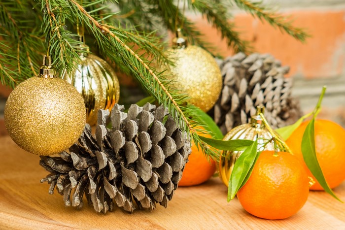 Christmas ornaments, pine cones, and tangerines