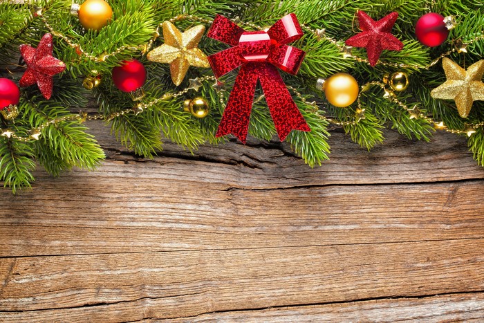 Christmas branches with ornaments and bow on wood