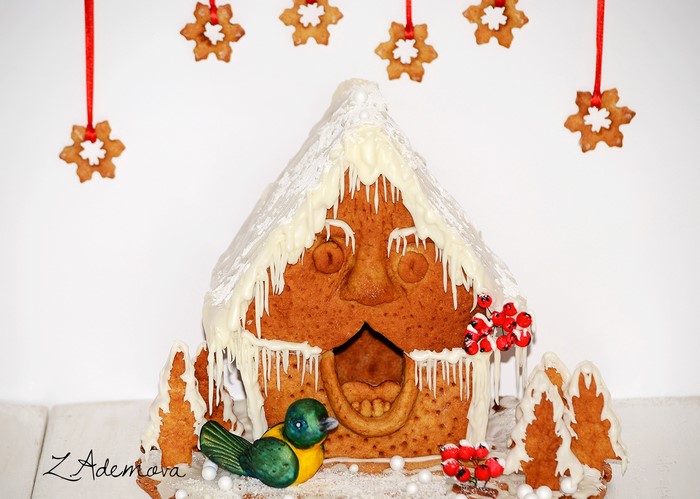 Gingerbread house with bird and snowflake cookies