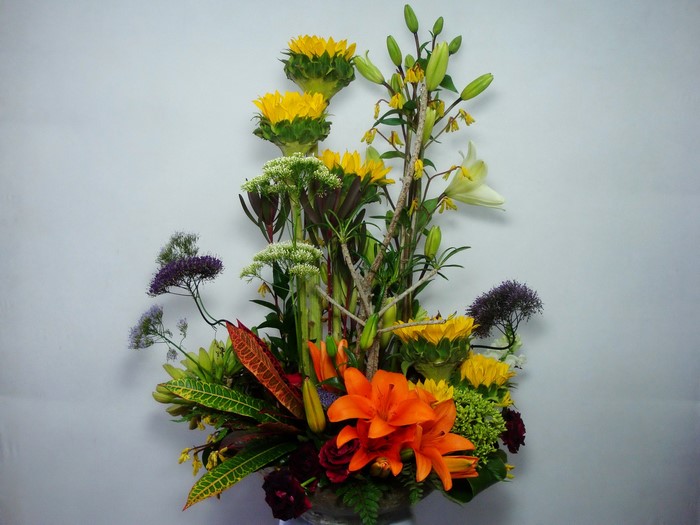 Floral arrangement with sunflowers, lilies, and roses