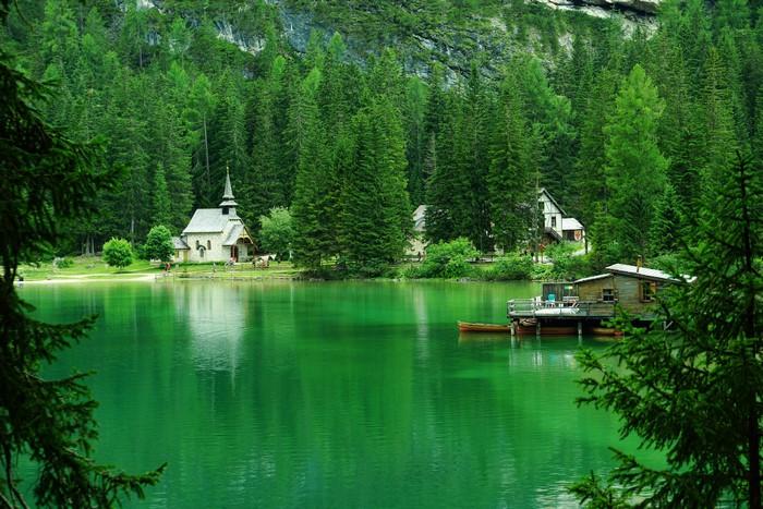 Lake Braies with a church and boathouse in Italy