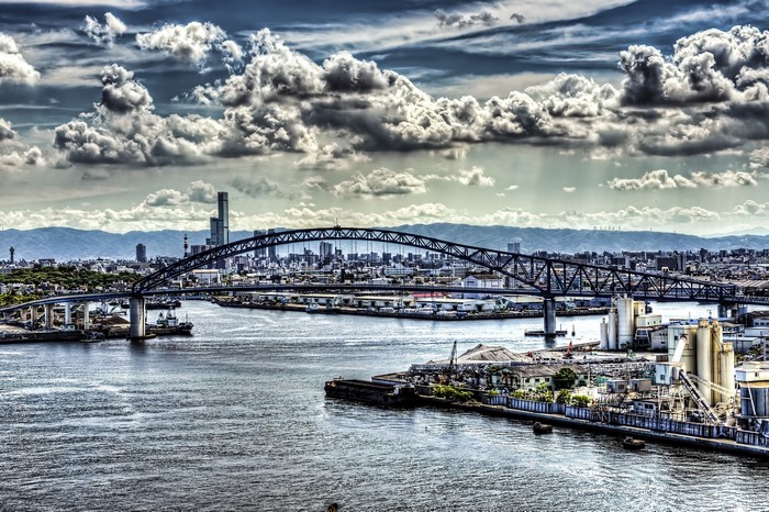 Bridge over water in Japan with city and mountains