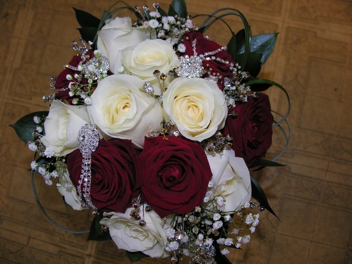 Wedding bouquet of red and white roses with brooches
