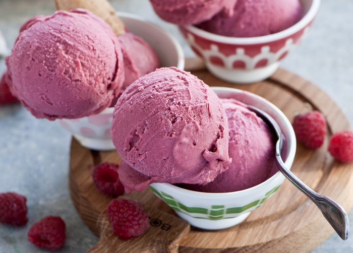 Raspberry ice cream in bowls with fresh raspberries
