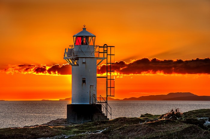 Lighthouse at sunset over the ocean