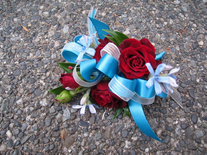 Red roses corsage with blue ribbons