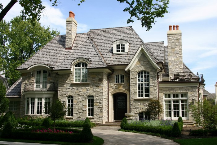 Stone mansion with manicured gardens and trees