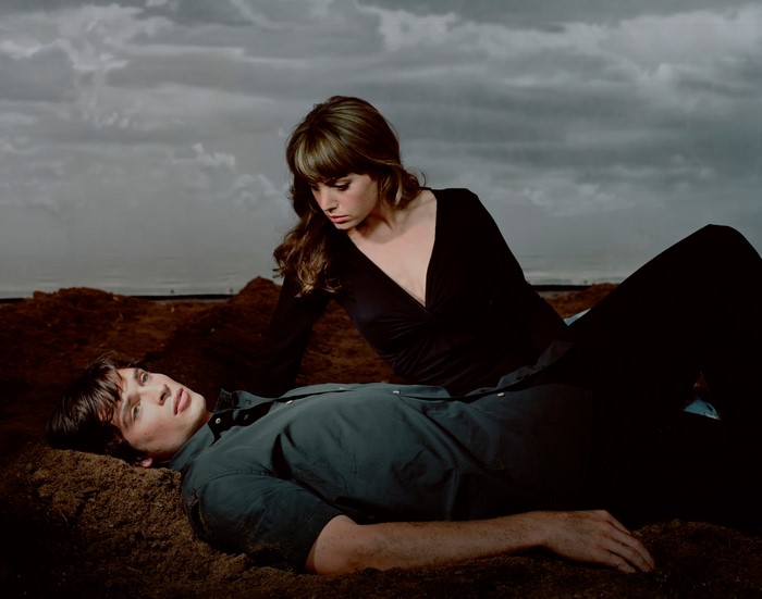 Man and woman lying on dirt