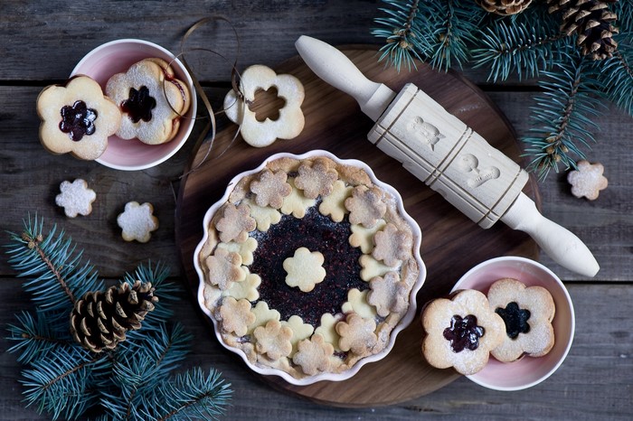 Christmas pie and cookies with pine branches and rolling pin