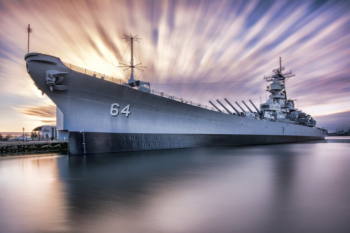 USS Wisconsin battleship at sunset with streaking clouds