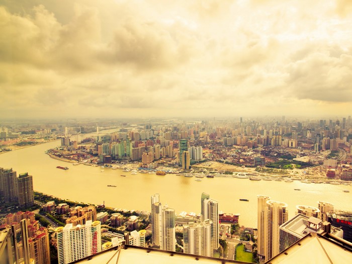 Aerial view of Shanghai megapolis with river and skyscrapers