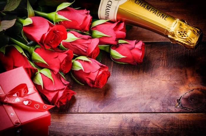 Red Roses, Champagne, and Gift Box on Wood