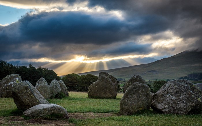 Stone circle with sun rays breaking through clouds
