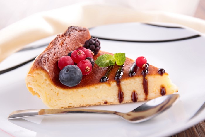 Slice of cheesecake with berries and chocolate sauce
