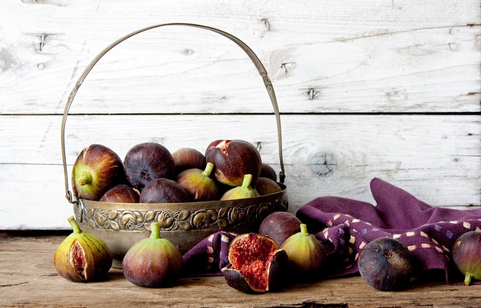 Basket of fresh figs on a wooden table