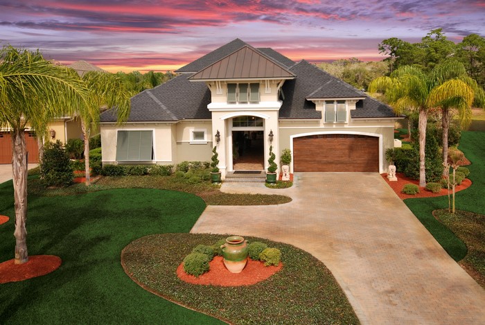 Luxury house with palm trees and sunset sky