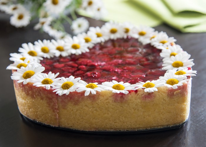 Heart-shaped cake with raspberries and daisies
