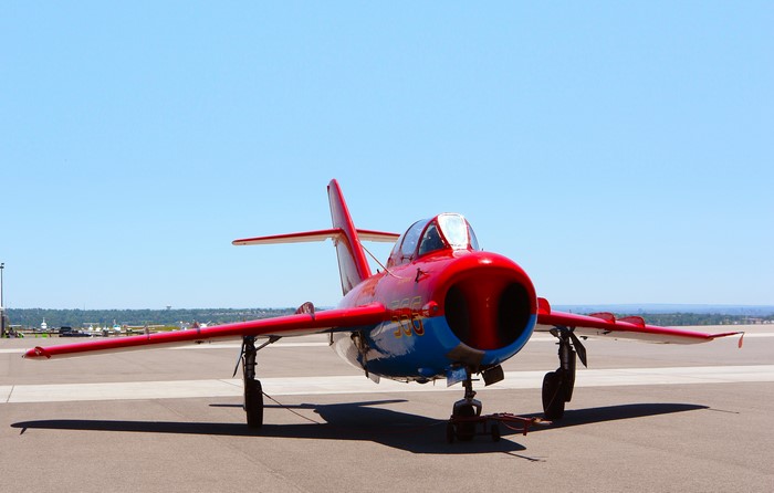 Red and blue Mig-17 Fresco fighter jet on tarmac