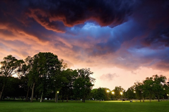Stormy sunset clouds over a park with trees