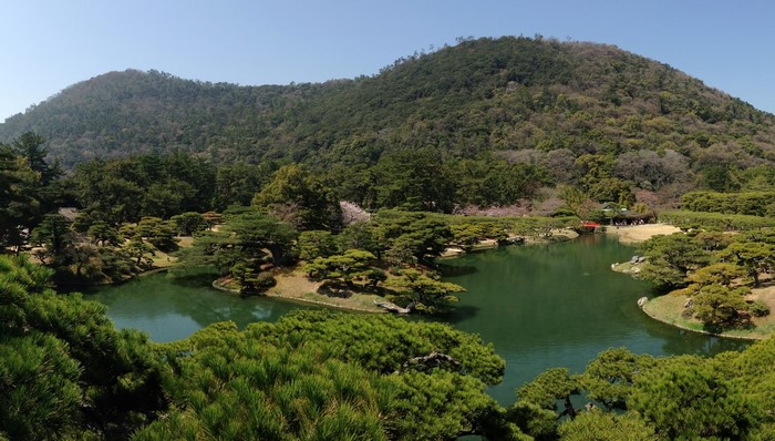 Ritsurin Garden pond with trees and mountain in Takamatsu, Japan