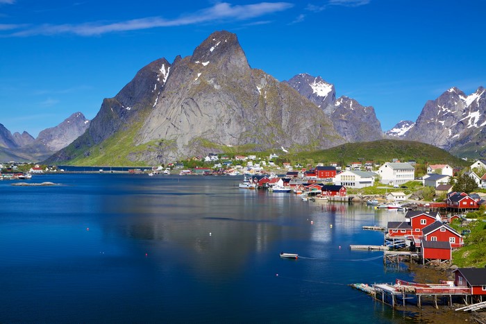 Red houses by a lake with mountains in Lofoten, Norway
