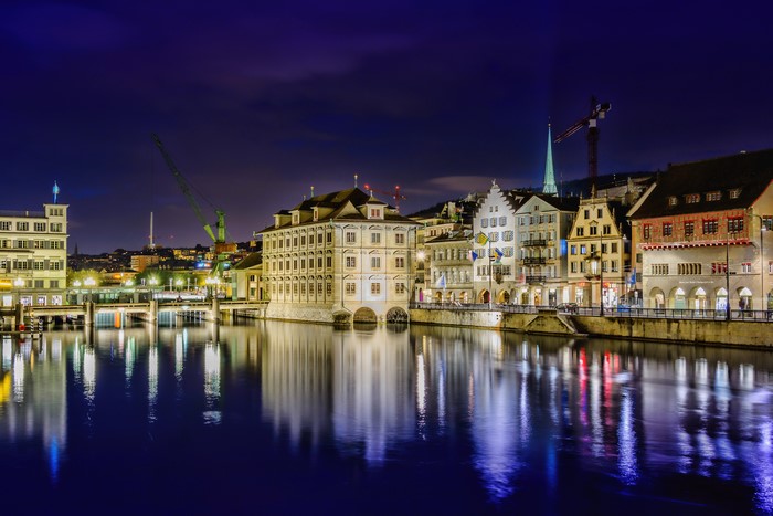 Night view of buildings along a river in Switzerland