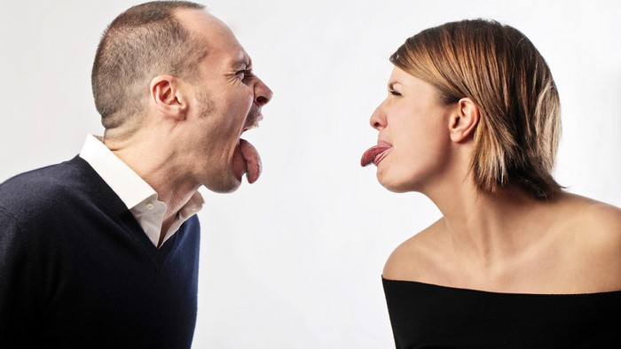 Man and woman sticking tongues out at each other