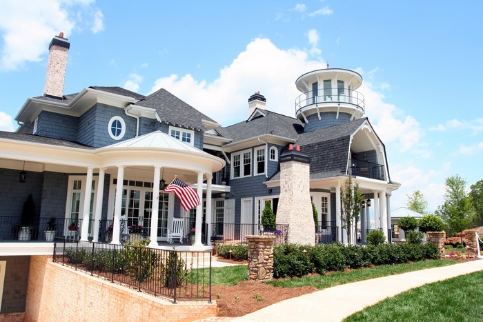 Large blue house with a lighthouse-style tower and porch