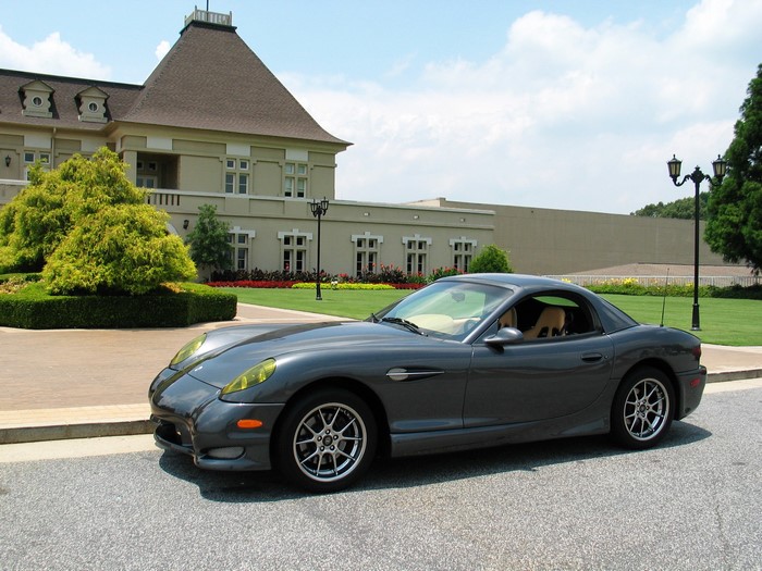 Grey 2004 Panoz Esperante parked in front of a building