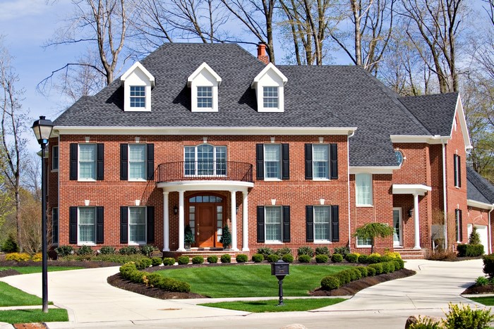 Brick Mansion with Dormer Windows and Landscaped Lawn