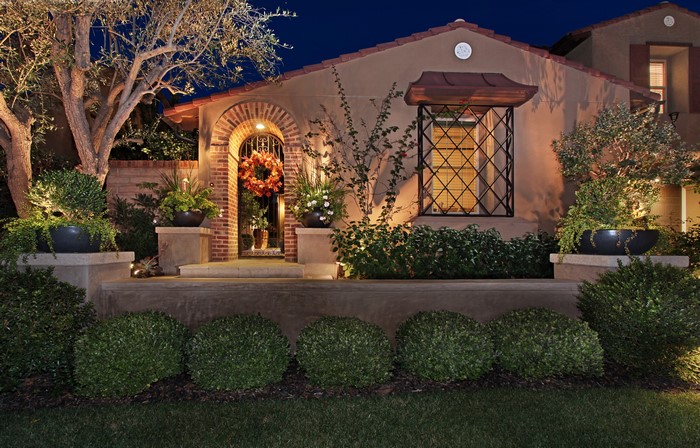 House exterior at night with illuminated landscaping