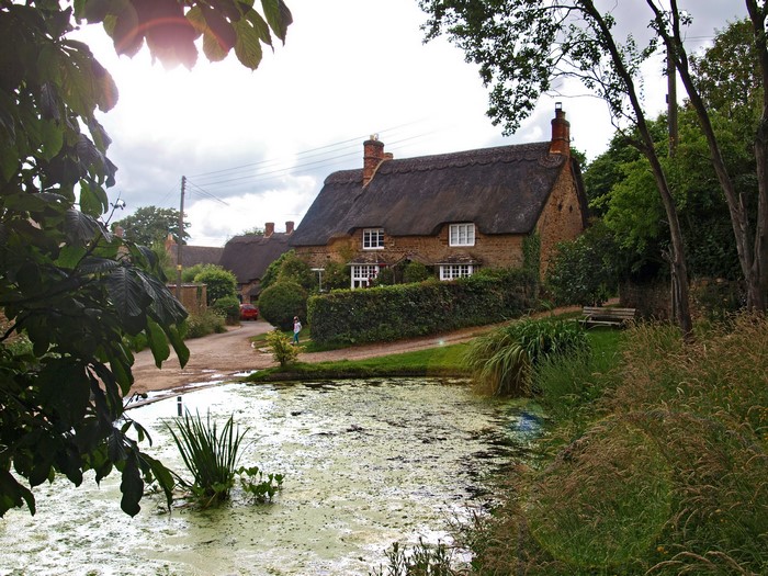 Thatched cottages by a pond in Sibford Gower, Oxfordshire