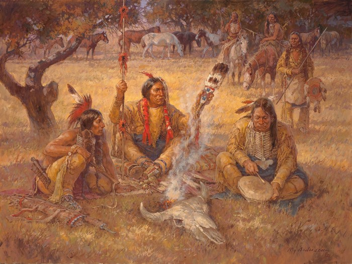 Native Americans gathered around a campfire with horses in the background