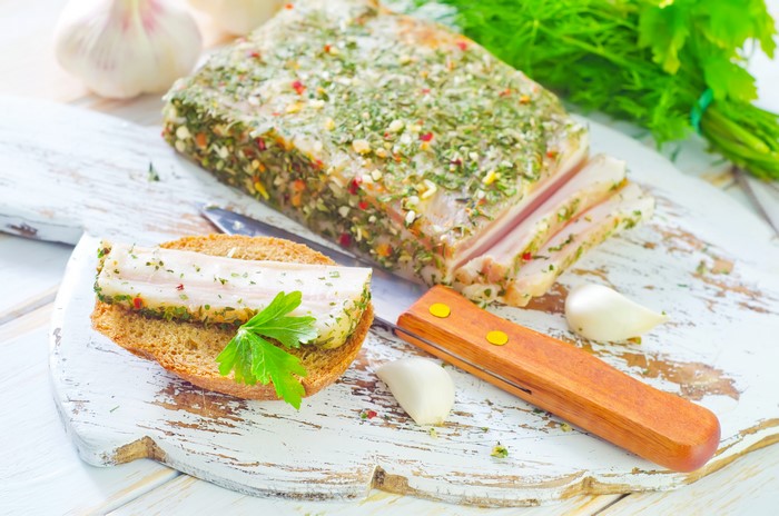 Salo with herbs on bread with garlic and knife