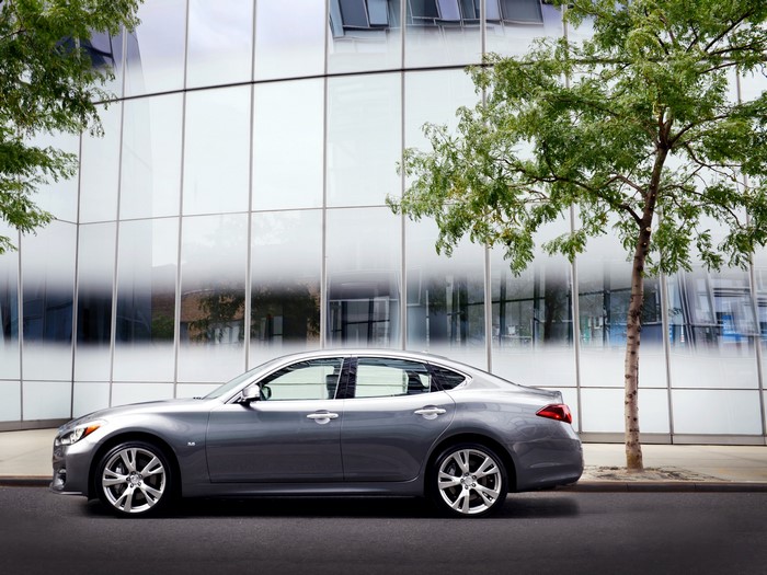 Silver Infiniti Q70 parked by a modern building