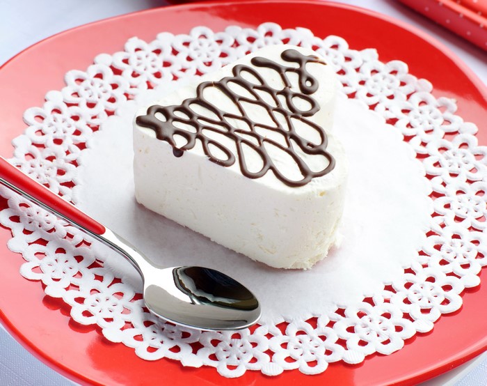 Heart-shaped cake with chocolate drizzle and spoon