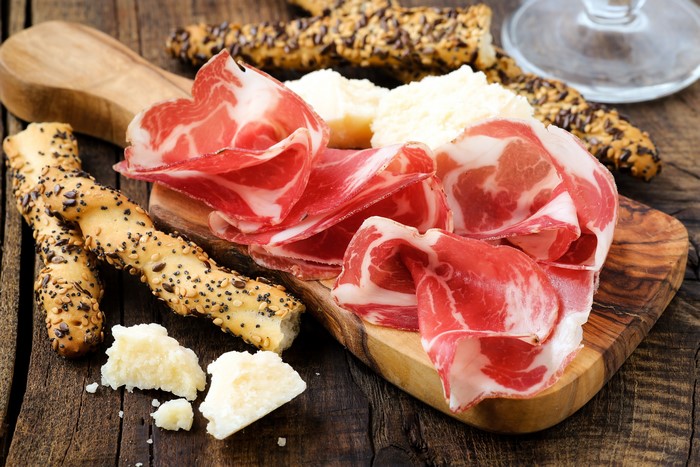 Meat products and pastry on a wooden board