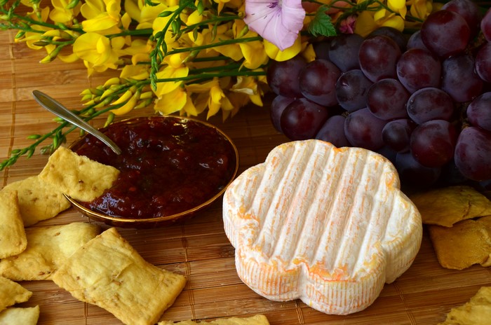 Cheese, Grapes, Jam, and Chips on a Bamboo Mat