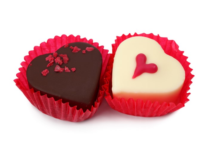 Two heart-shaped chocolates in red wrappers