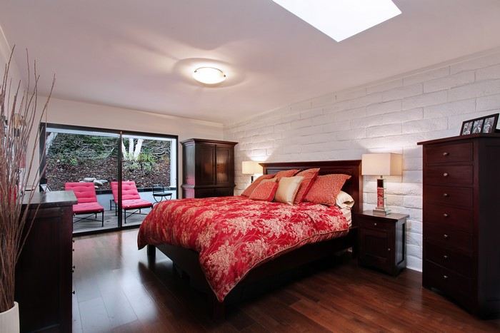 Bedroom with red bedding and patio access