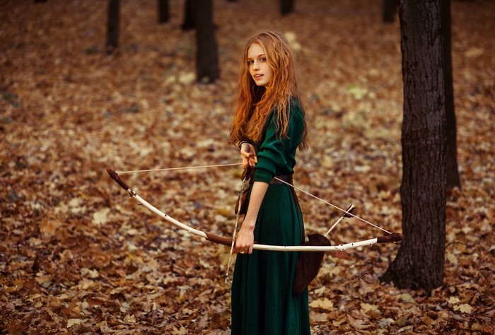 Redhead girl with bow in autumn forest