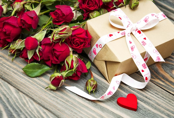 Red roses and a gift box with a heart ribbon