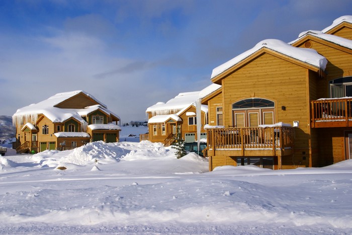 Wooden houses covered in snow with icicles